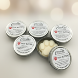 Five tins of The Corner Handmade Paw Butter on a light background