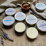 Collection of Corner Handmade lotion bars and containers on a wooden surface.